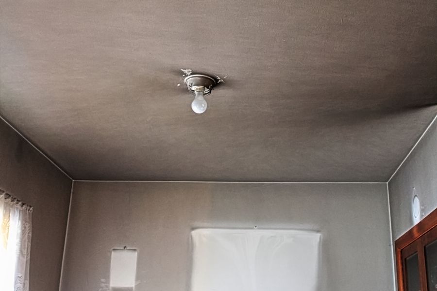 Smoke residue discoloring a ceiling and upper walls in a residential home after a fire