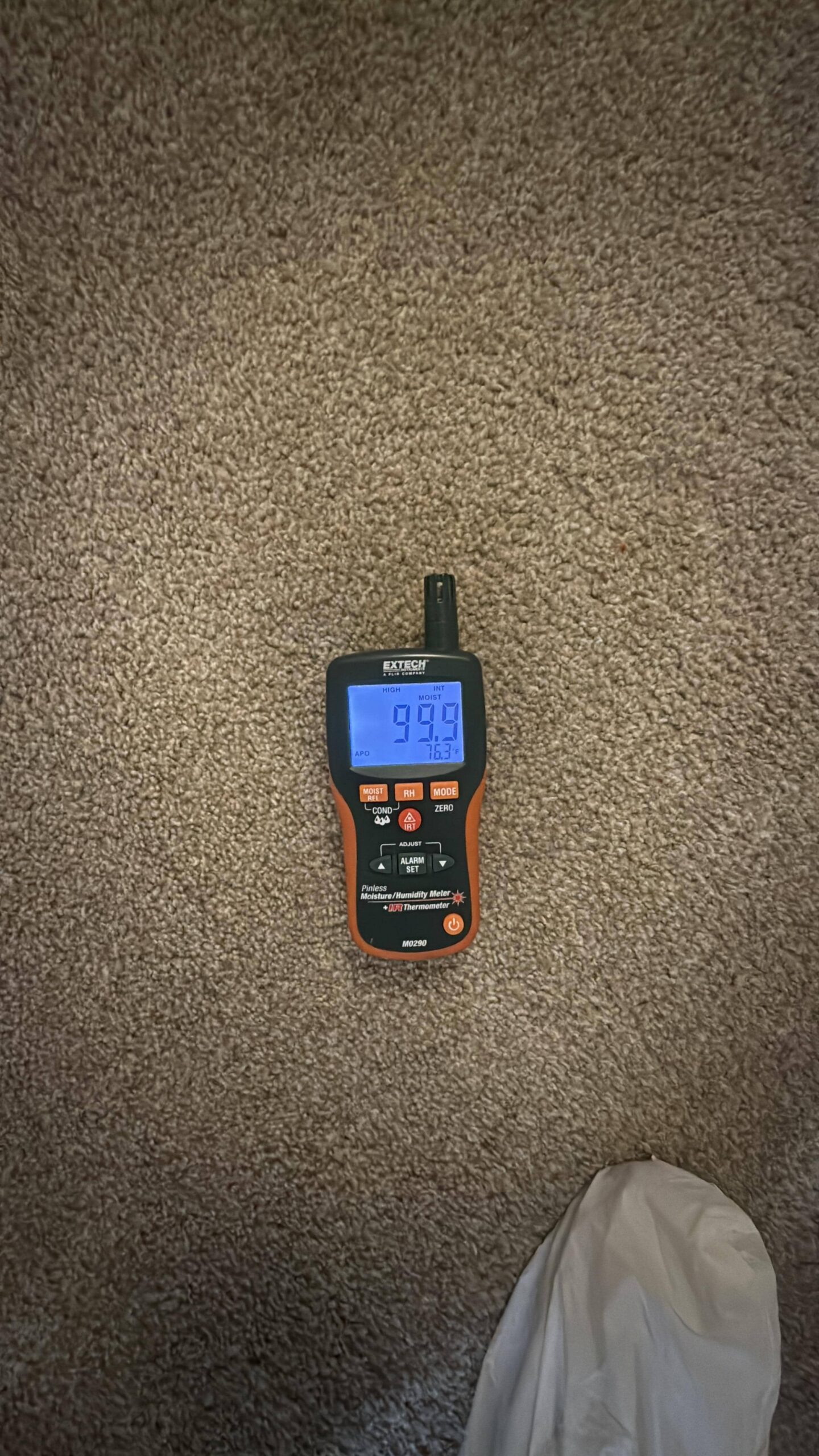 Technician taking carpet moisture readings during water damage assessment in Maricopa AZ home