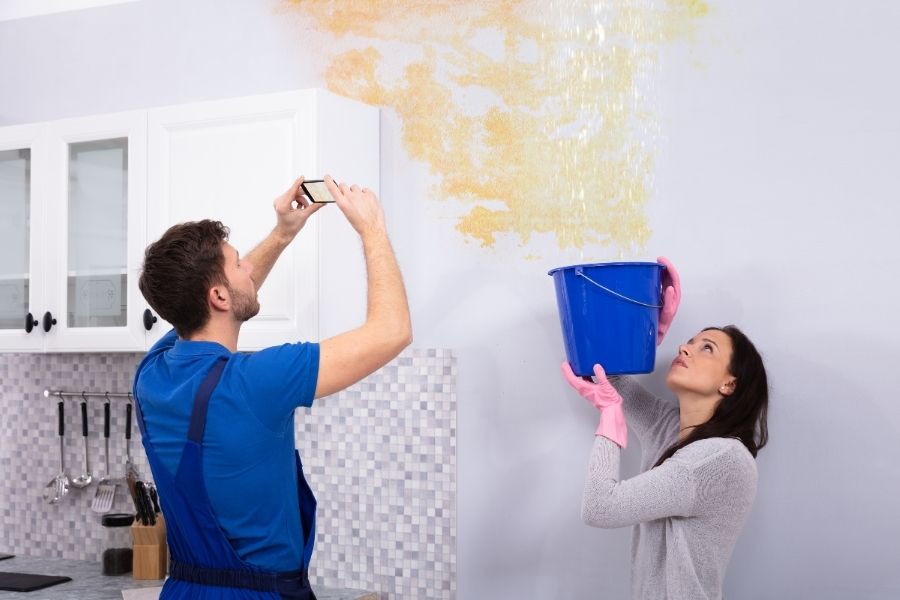 Homeowner documenting water damage with photos for an insurance claim