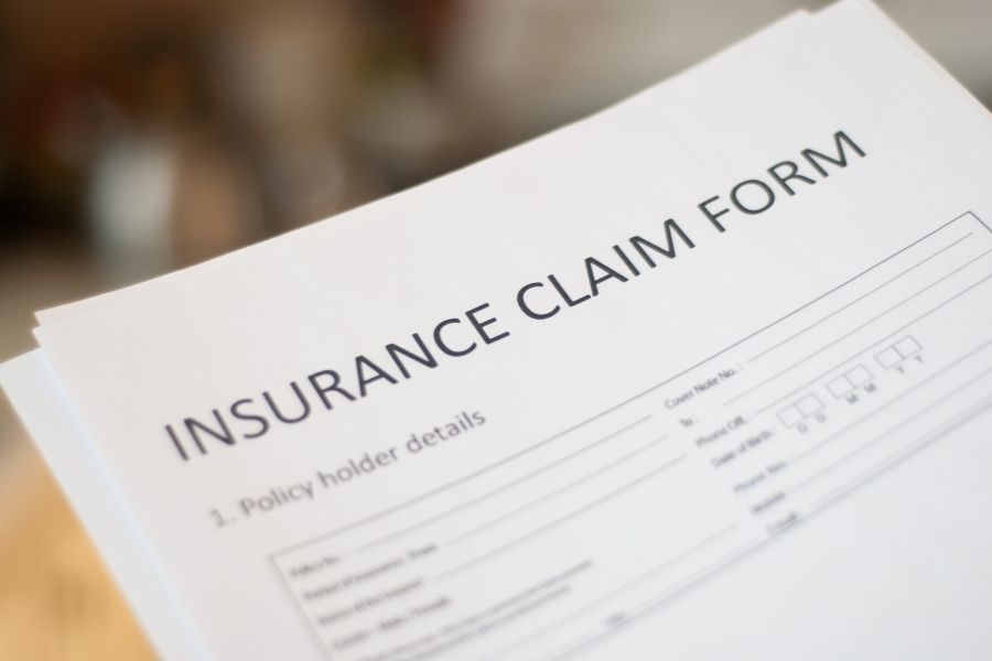 Homeowner reviewing an insurance claim form after water damage