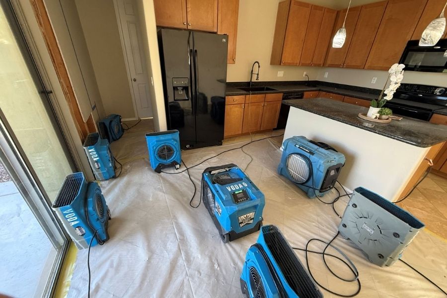 Professional drying equipment set up during kitchen water damage restoration
