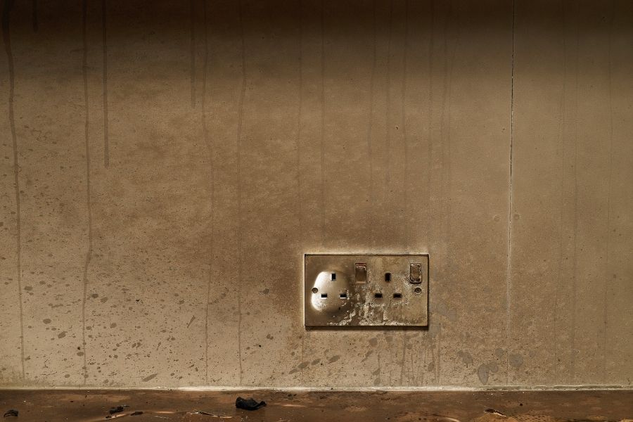 Soot buildup and discoloration on an electrical outlet after a fire event