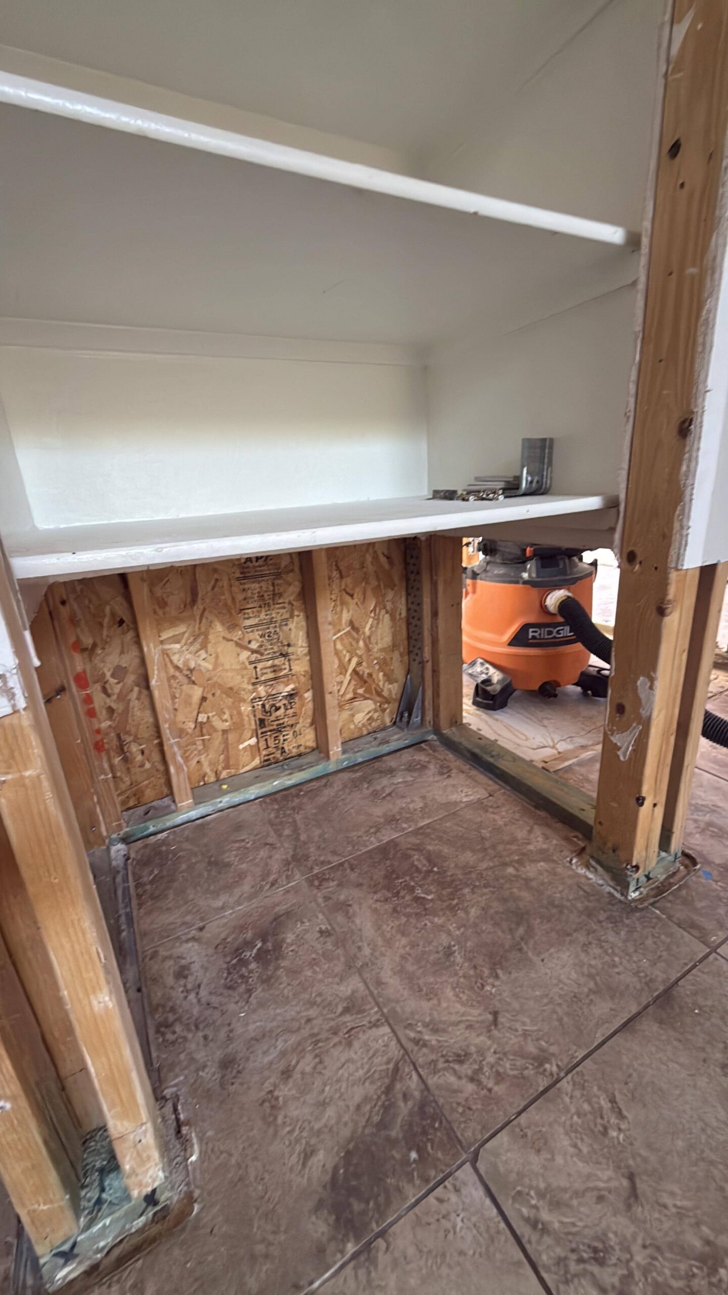 Hallway after flood cut demolition and drying showing clean wall framing