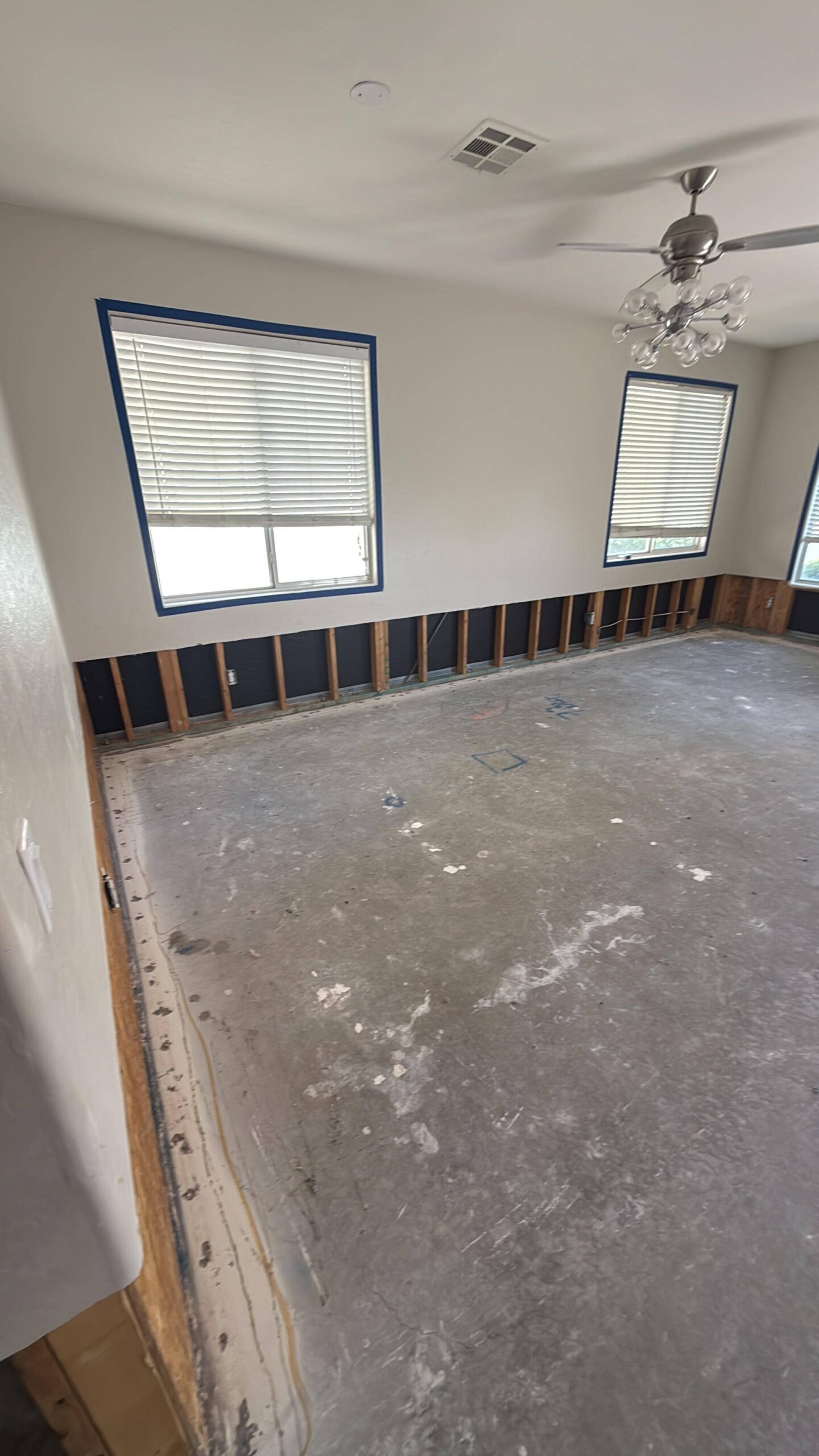 Master bedroom after water damage mitigation with carpet removed and walls dried
