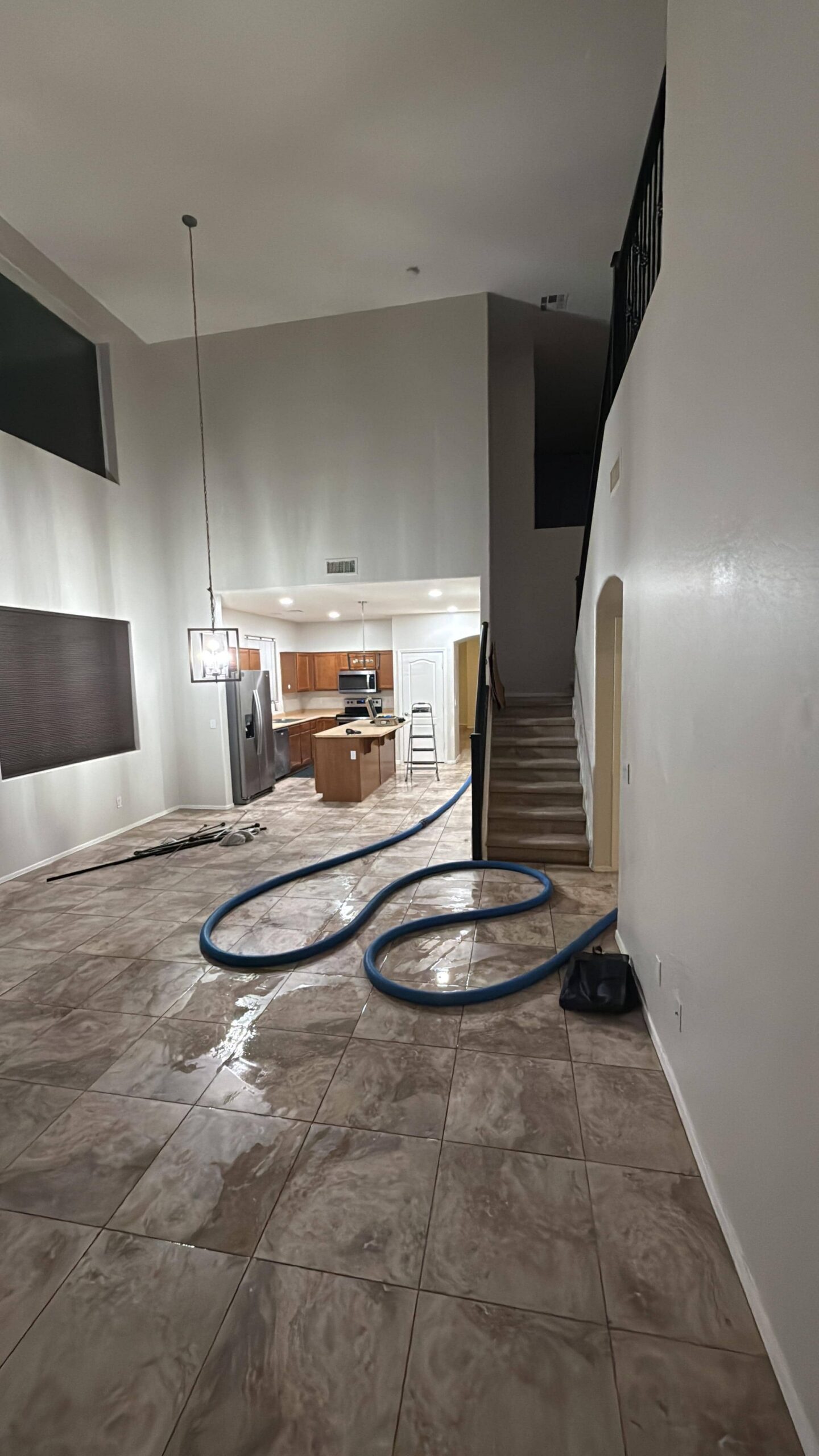 Water extraction equipment removing standing water from flooded room